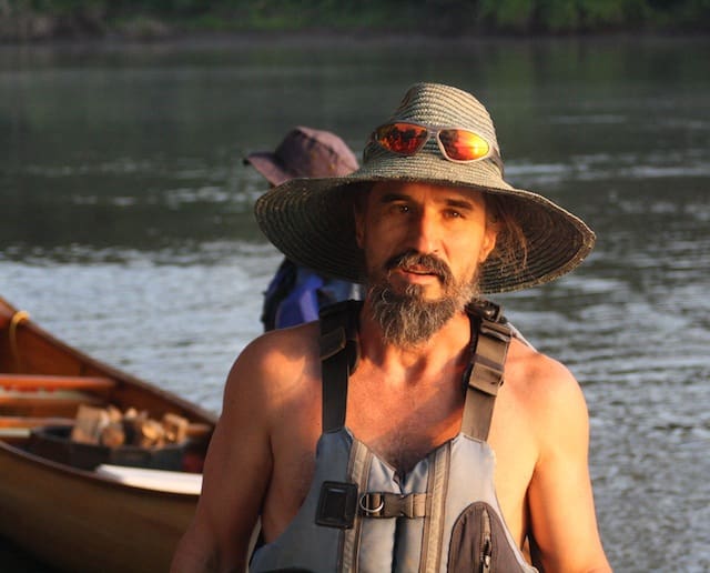 Person wearing sunglasses and life jacket outdoors