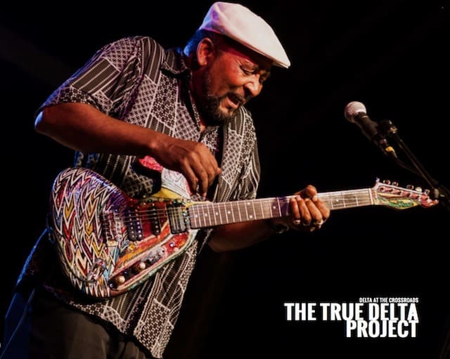 Man in hat playing electric guitar live