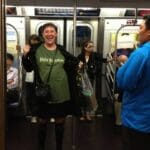 Woman in a green shirt on a subway train.