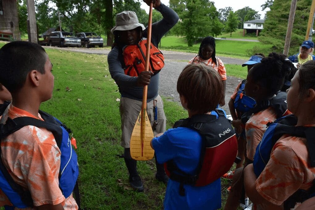 Instructor showing paddle to kids