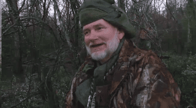 Man in forest wearing camouflage and hat