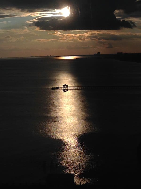 Dramatic clouds and shimmering ocean reflection