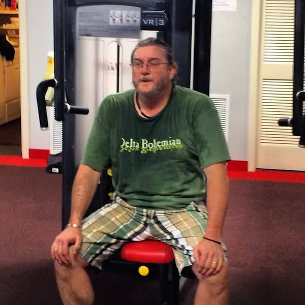 Man sitting on gym equipment