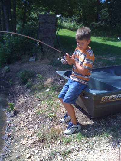Young angler with fishing rod outdoors