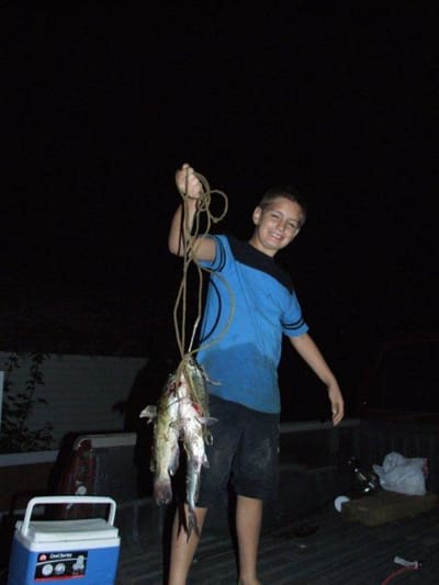 Boy holding a string of fish
