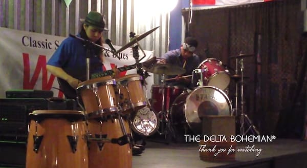 Musicians performing on stage with drums