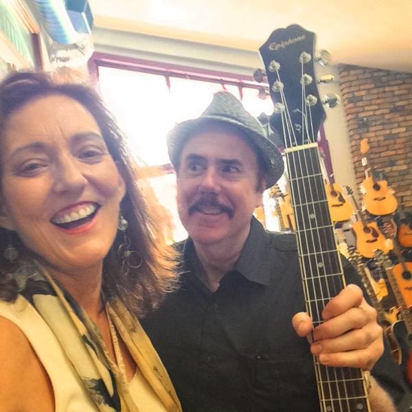 Happy duo with guitars in background