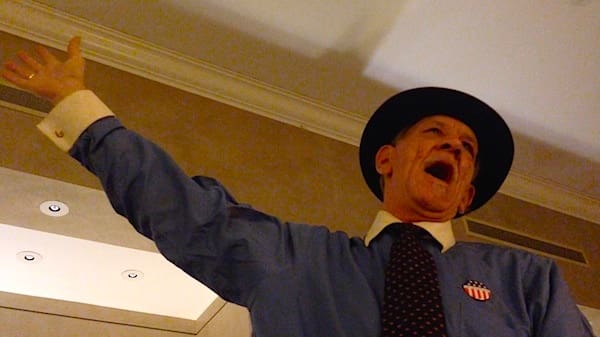 Man in blue shirt singing passionately