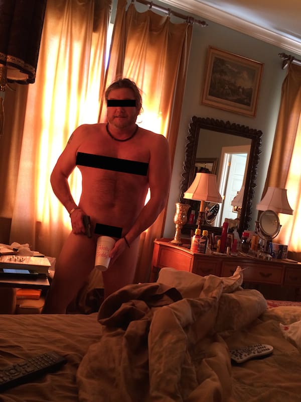 Person standing near bed with lamp