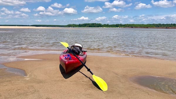 Yellow paddle beside red kayak