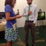 Woman and man talking in gallery setting.
