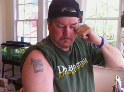 Man showing arm tattoo indoors