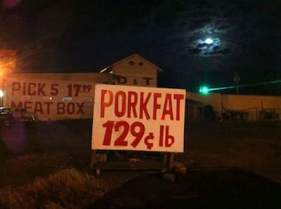 Rustic sign advertising porkfat at night