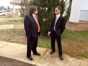 Two men in suits talking on sidewalk