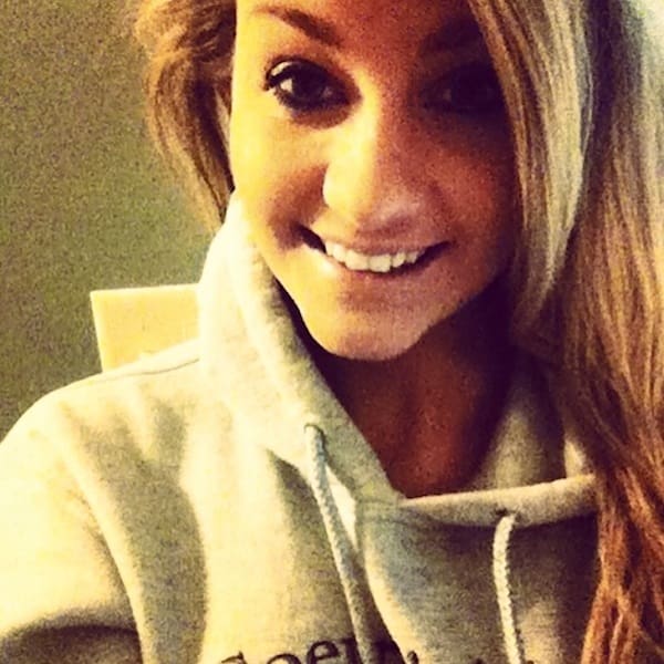 Smiling woman wearing gray hoodie selfie