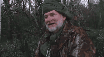 Bearded man in camo jacket in forest