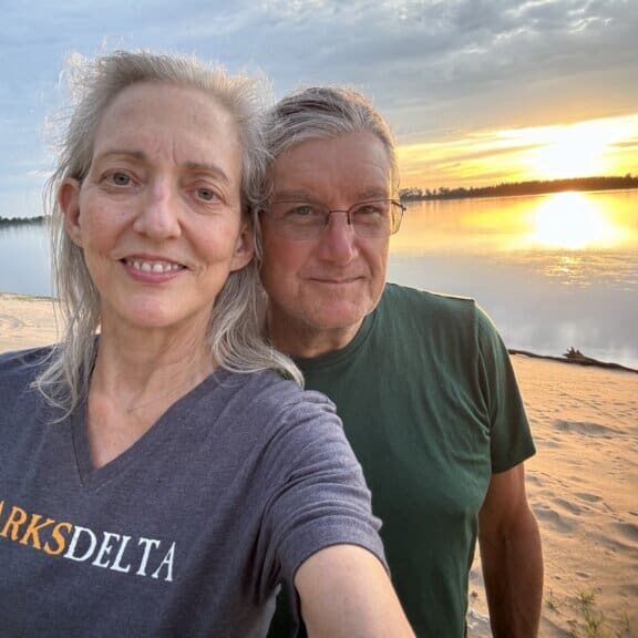 Happy pair enjoying lakeside sunset view