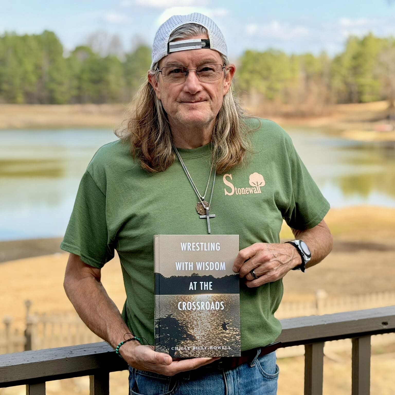Chilly Billy holding his book Wrestling with Wisdom at the Crossroads